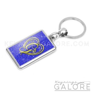 chrome plated key ring key chain personalized with monogram gold initial and blue glitter background