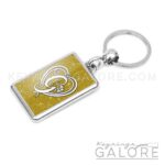 chrome plated key ring key chain personalized with monogram white initial and gold glitter background