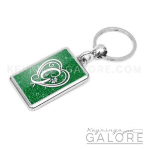 chrome plated key ring key chain personalized with monogram white initial and green glitter background