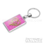 chrome plated key ring key chain personalized with monogram gold initial and pink glitter background