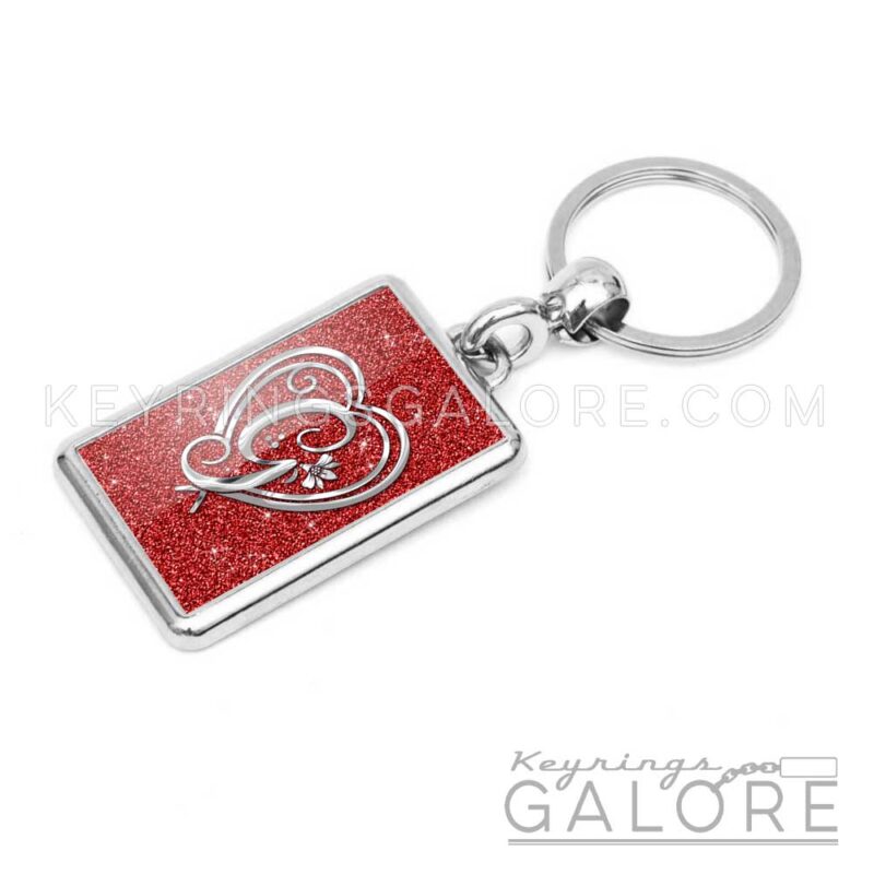 chrome plated key ring key chain personalized with monogram silver initial and red glitter background