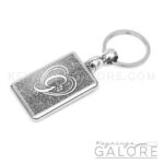 chrome plated key ring key chain personalized with monogram white initial and silver glitter background